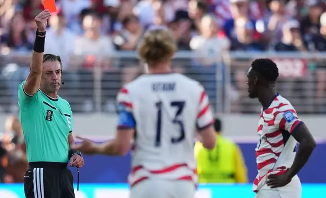 Referee Raphael Claus of Brazil shows a red card to United States' Folarin Balogun, right, during the World Cup round of 32 soccer match between the United States and Bosnia in Santa Clara, Calif., near San Francisco, Wednesday, July 1, 2026. (AP Photo/Julio Cortez)
