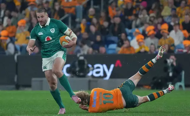 Ireland's Stuart McCloskey gets past he diving Australia's Carter Gordon during the Nations Championship rugby international between Australia and Ireland in Sydney, Saturday July, 4, 2026. (AP Photo/Mark Baker)