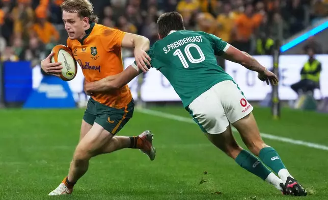 Australia's Max Jorgensen tries to evade the tackle of Ireland's Sam Prendergast during the Nations Championship rugby international between Australia and Ireland in Sydney, Saturday July, 4, 2026. CORRECTION: corrects ID to Australia's Max Jorgensen to replace Joseph-Aukuso Suaalii (AP Photo/Mark Baker)