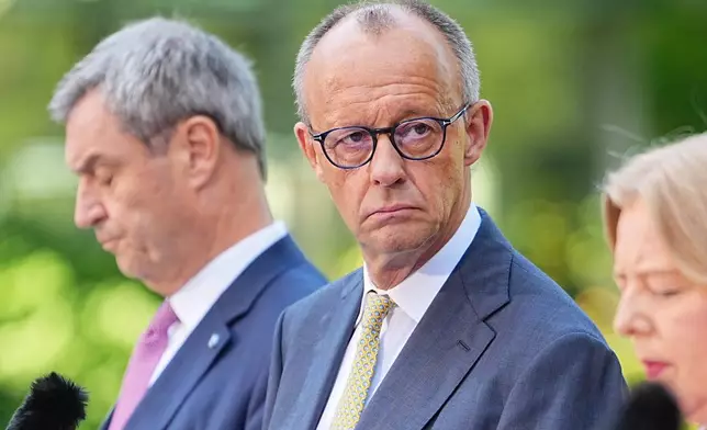 German Federal Chancellor Friedrich Merz, center, attends a press conference with Minister-President of Bavaria and CSU Chairman Markus Söder, left, Federal Minister of Labor and Social Affairs Bärbel Bas, right and Federal Minister of Finance, Lars Klingbeil, in the garden of the Chancellery following the meeting of the coalition committee, in Berlin, Thursday, July 2, 2026. (Michael Kappeler/dpa via AP)