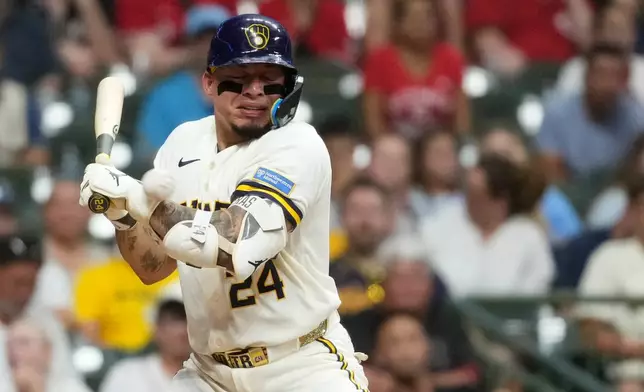 Milwaukee Brewers' William Contreras gets hit by a pitch during the eighth inning of a baseball game against the Cincinnati Reds, Wednesday, July 1, 2026, in Milwaukee. (AP Photo/Aaron Gash)