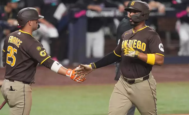 San Diego Padres' Xander Bogaerts, right, scored on a an fielding error during the fifth inning of a baseball game against the Miami Marlins Friday, July 24, 2026, in Miami. (AP Photo/Marta Lavandier)