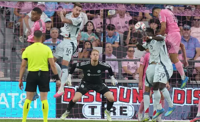 Chicago Fire forward Jonathan Bamba (19) heads the ball as goalkeeper Chris Brady (1) defends the goal during the first half of an MLS soccer match against Inter Miami, Wednesday, July 22, 2026, in Miami. (AP Photo/Lynne Sladky)