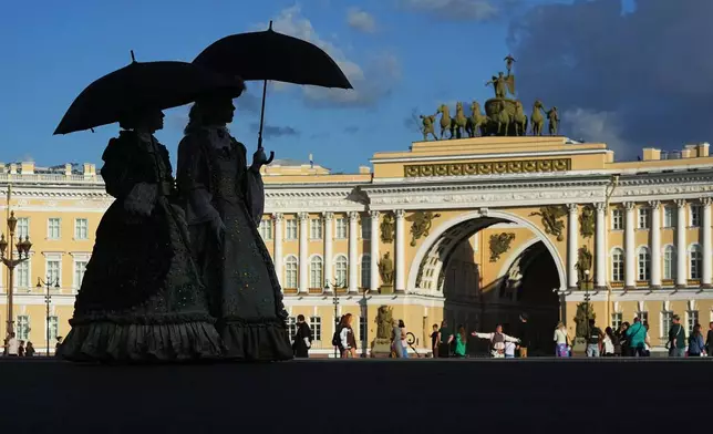 Women wearing 18th-century costumes walk at the Palace Square in St. Petersburg, Russia, Thursday, July 9, 2026. (AP Photo/Dmitri Lovetsky)