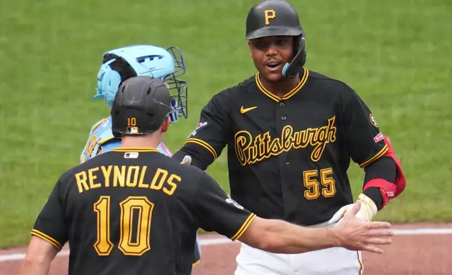 Pittsburgh Pirates' Esmerlyn Valdez (55) celebrates with Bryan Reynolds (10) after hitting a two-run home run off Milwaukee Brewers pitcher Shane Drohan during the fourth inning of the second game of a baseball doubleheader in Pittsburgh, Saturday, July 11, 2026. (AP Photo/Gene J. Puskar)