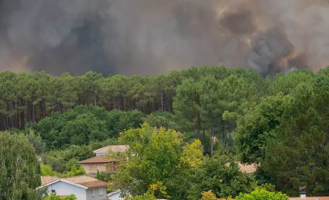 Smoke rises over wildfires in the Lège-Cap-Ferret region, western France, Thursday, July 23, 2026. (AP Photo/Caroline Blumberg)
