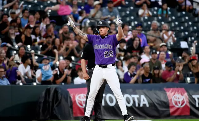 Colorado Rockies' Mickey Moniak celebrates on third base after hitting a two-run triple in the fifth inning of a baseball game against the Miami Marlins Wednesday, July 1, 2026, in Denver. (AP Photo/Geneva Heffernan)
