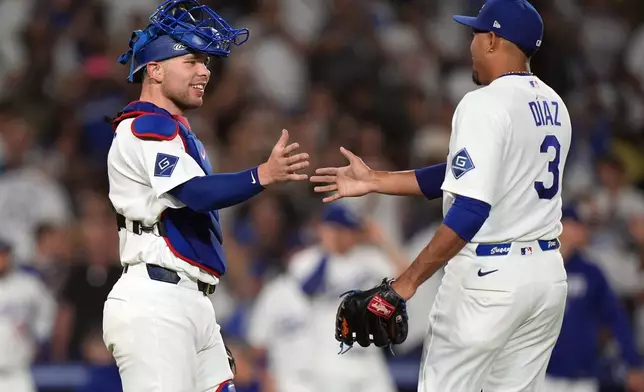 Los Angeles Dodgers relief pitcher Edwin Diaz (3) is congratulated by catcher Dalton Rushing (68) after Diaz earned the save against the Seattle Mariners during the ninth inning of a baseball game Wednesday, July 29, 2026, in Los Angeles. (AP Photo/Scott Strazzante)