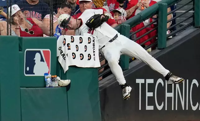 Cleveland Guardians left fielder Cooper Ingle hangs over the left field fence after catching a fly ball hit by Chicago White Sox's Drew Romo for an out in the sixth inning of a baseball game in Cleveland, Saturday, July 4, 2026. (AP Photo/Sue Ogrocki)