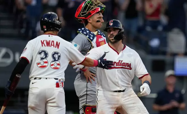 Cleveland Guardians' Austin Hedges, right, celebrates with Steven Kwan (38) in front of Chicago White Sox catcher Drew Romo after hitting a home run in the fifth inning of a baseball game in Cleveland, Saturday, July 4, 2026. (AP Photo/Sue Ogrocki)