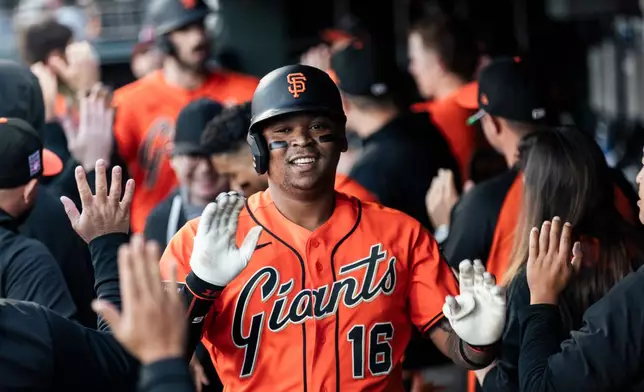 San Francisco Giants' Rafael Devers (16) high-fives teammates in the dugout after hitting a two-run home run during the first inning of a MLB baseball game against the Los Angeles Angels in San Francisco, Friday, July 24, 2026. (Stephen Lam/San Francisco Chronicle via AP)