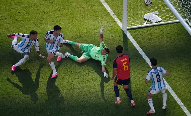 Argentina goalkeeper Emiliano Martinez (23) fails to save a shot by Spain's Ferran Torres (7) who scored their opening goal during the World Cup final soccer match between Spain and Argentina in East Rutherford, N.J., near New York, Sunday, July 19, 2026. (AP Photo/Matt Slocum)
