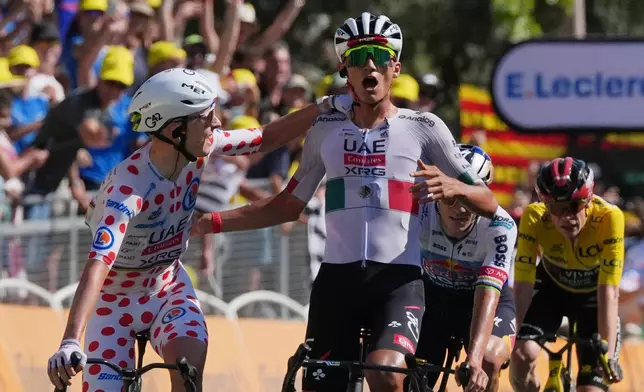 Mexico's Isaac Del Toro, right, celebrates with Slovenia's Tadej Pogacar as he crosses the finish line to win the second stage of the Tour de France cycling race with start in Tarragone and finish in Barcelona, Spain, Sunday, July 5, 2026. (AP Photo/Thibault Camus)
