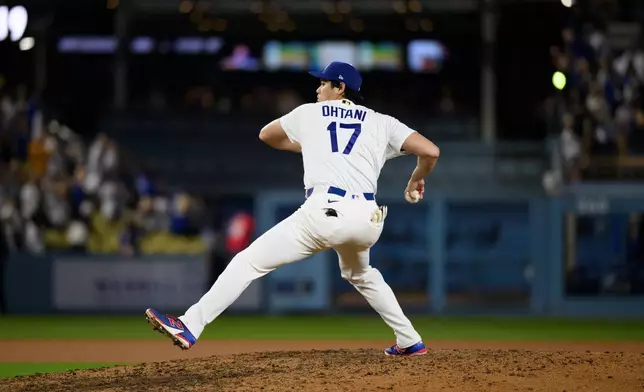 Los Angeles Dodgers' Shohei Ohtani pretends to pitch after a baseball game against the San Diego Padres in Los Angeles, Thursday, July 2, 2026. (AP Photo/Kyusung Gong)