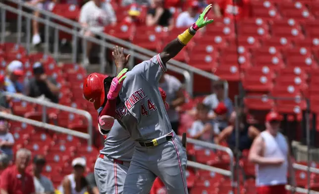 Cincinnati Reds' Elly de la Cruz (44) reacts with third base coach Willie Harris, back, after hitting a home run against the St. Louis Cardinals during the third inning of a baseball game, Sunday, July 26, 2026, in St. Louis. (AP Photo/Jeff Le)