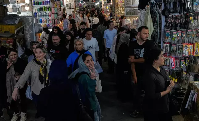 A woman flashes a victory sign while walking at Tehran's traditional main bazaar, Iran, Thursday, July 16, 2026. (AP Photo/Vahid Salemi)