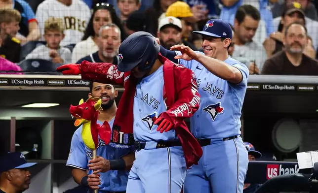 Toronto Blue Jays' Brandon Valenzuela, right, puts a home run jacket on Kazuma Okamoto, left, after Okamoto hit a three-run home run against the San Diego Padres in the fifth inning of a baseball game Friday, July 10, 2026, in San Diego. (AP Photo/Derrick Tuskan)