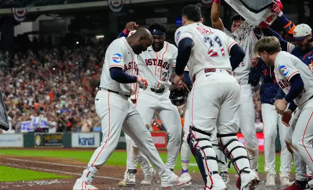 Houston Astros designated hitter Yordan Alvarez, left, celebrates with teammates at home after hitting a two-run walkoff home run during the ninth inning of a baseball game against the Tampa Bay Rays in Houston, Saturday, July 4, 2026. (AP Photo/Jon Shapley)