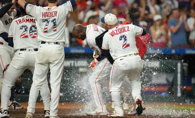 Houston Astros' Christian Vázquez dumps an ice chest on Houston Astros designated hitter Yordan Alvarez after he hit a walk-off home run during the ninth inning of a baseball game against the Tampa Bay Rays in Houston, Saturday, July 4, 2026. (AP Photo/Jon Shapley)