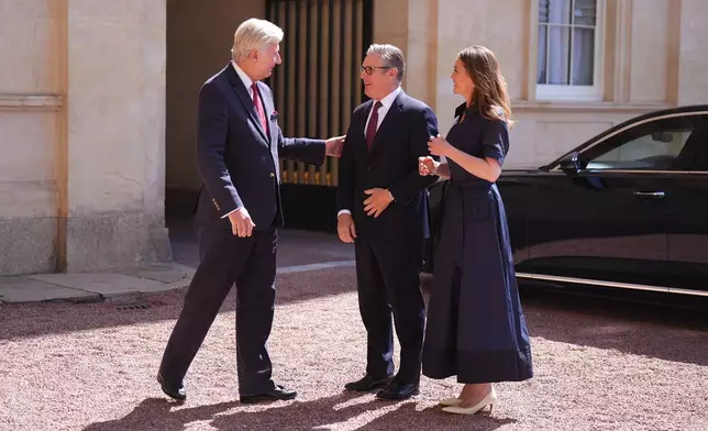 Sir Clive Alderton, left, Principal Private Secretary to the King and Queen, left, greets outgoing Prime Minister Keir Starmer and his wife Victoria, as he arrives at Buckingham Palace in London, Monday July 20, 2026. (Aaron Chown/Pool Photo via AP)