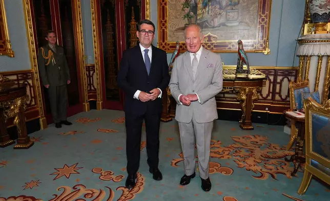 Britain's King Charles III welcomes Andy Burnham, left, during an audience at Buckingham Palace, London, where he invited the leader of the Labour Party to become Prime Minister and form a new government, Monday July 20, 2026. (Aaron Chown/Pool Photo via AP)