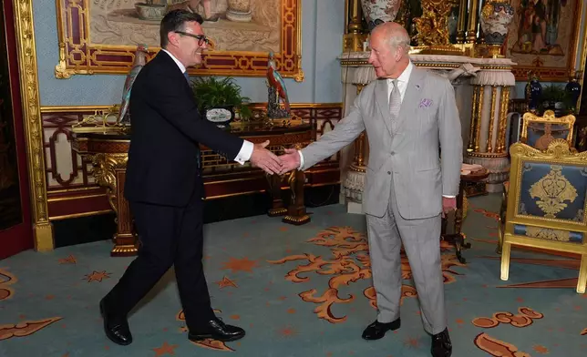 Britain's King Charles III welcomes Andy Burnham, left, during an audience at Buckingham Palace, London, where he invited the leader of the Labour Party to become Prime Minister and form a new government, Monday July 20, 2026. (Aaron Chown/Pool Photo via AP)