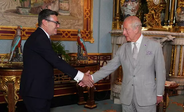 Britain's King Charles III welcomes Andy Burnham, during an audience at Buckingham Palace, London, where he invited the leader of the Labour Party to become Prime Minister and form a new government, Monday July 20, 2026. (Aaron Chown/Pool Photo via AP)