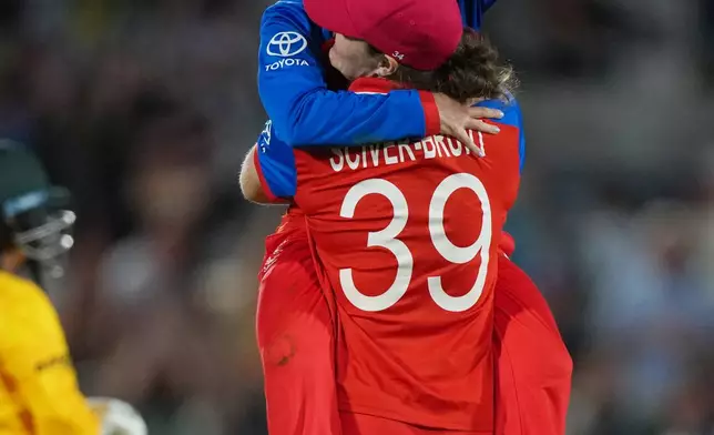 England's Sophie Ecclestone, back to the camera, celebrates with Linsey Smith, top, after winning the Women's T20 Cricket World Cup semifinal match between England and South Africa in London, Thursday, July 2, 2026. (AP Photo/Alastair Grant)