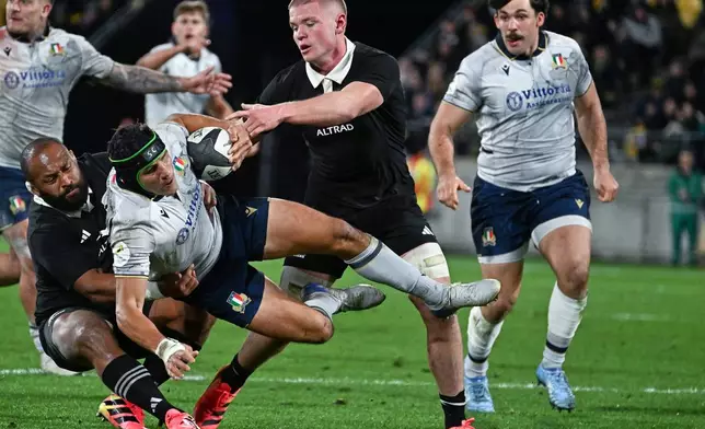 Juan Ignacio Brex, centre, of Italy is tackled New Zealand's George Bower and Anton Segner during the Nations Championship rugby international between the All Blacks and Italy in Wellington, New Zealand, Saturday, July 11, 2026. (Masanori Udagawa/Photosport via AP)