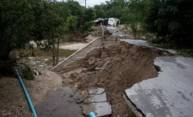 A partially-collapsed bridge crossing Goat Creek is damaged following floods near the Guadalupe River on Friday, July 17, 2026, in Kerrville, Texas. (AP Photo/Joel Angel Juarez)