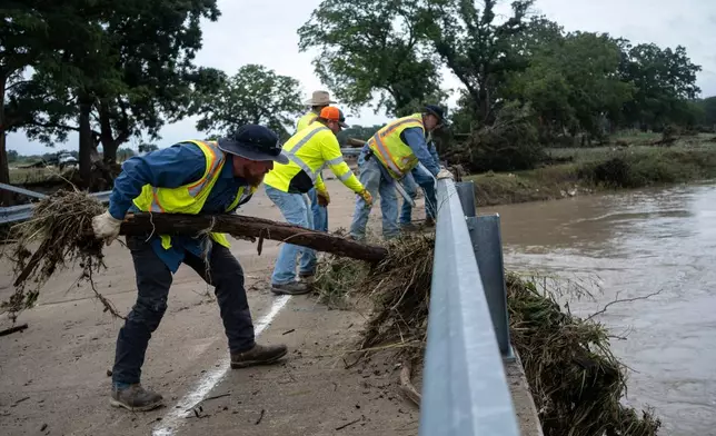 Crews clean up flood debris along the Guadalupe River on Friday, July 17, 2026, in Comfort, Texas. (AP Photo/Joel Angel Juarez)