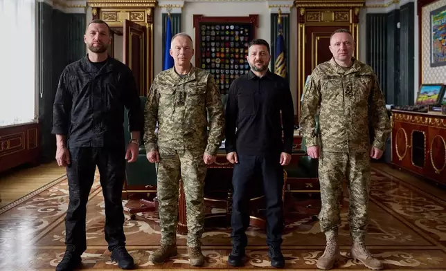 In this photo provided by the Ukrainian Presidential Press Office, from left, acting Minister of Defense Major General Yevhen Khmara, former Commander-in-Chief of the Ukrainian Armed Forces Oleksandr Syrskyi, Ukrainian President Volodymyr Zelenskyy and new commander-in-chief of Ukraine's Armed Forces Mykhailo Drapatyi, pose for a photo during their meeting in Kyiv, Ukraine, Wednesday, July 22, 2026. (Ukrainian Presidential Press Office via AP)