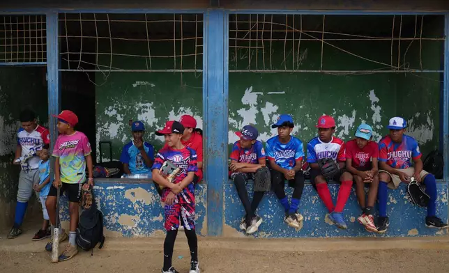 Young baseball players gather before a game in La Guaira, Venezuela, Saturday, July 11, 2026, during the return of youth league baseball practice after earthquakes struck one of the country's most baseball-loving regions. (AP Photo/Ariana Cubillos)