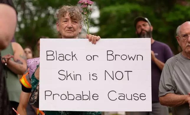 A woman holds a sign during a vigil, Tuesday, July 14, 2026, in Lewiston, Maine, a day after the shooting of Johan Sebastian Duran Guerrero by U.S. Immigration and Customs Enforcement. (AP Photo/Robert F. Bukaty)