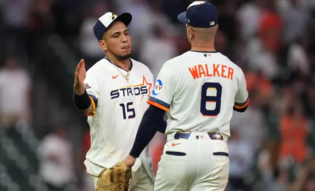 Houston Astros' Isaac Paredes (15) and Christian Walker (8) celebrate after a baseball game against the Miami Marlins, Monday, July 20, 2026, in Houston. (AP Photo/Karen Warren)