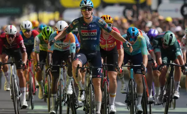 Belgium's Tim Merlier celebrates as he crosses the finish line to win the seventh stage of the Tour de France cycling race with start in Hagetmau and finish in Bordeaux, France, Friday, July 10, 2026. (AP Photo/Thibault Camus)