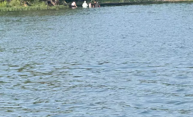 In this photo provided by Pastor Marcus L. Martin, a group of people he believes were those who died in a recent drowning accident, are shown fishing along the Scioto river in Powell, Ohio, Sunday, July 19, 2026. (Pastor Marcus L. Martin via AP)