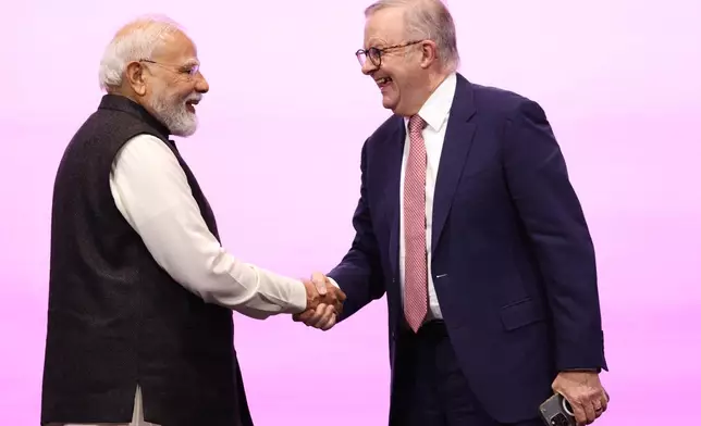 Indian Prime Minister Narendra Modi, left, is welcomed to the stage by Australian Prime Minister Anthony Albanese to address the Australia-India Economic Roadmap Business Reception in Melbourne, Australia, Thursday, July 9, 2026. (AP Photo/Hamish Blair)