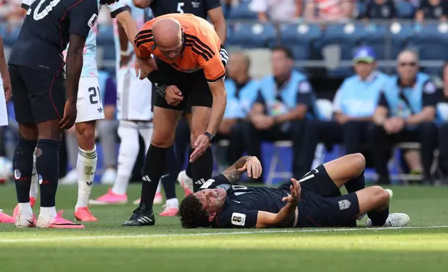 Referee Adham Makhadmeh, of Jordan, checks on United States' Christian Pulisic (10) after a challenge during the World Cup round of 16 soccer match between the United States and Belgium in Seattle, Monday, July 6, 2026. (AP Photo/Maddy Grassy)