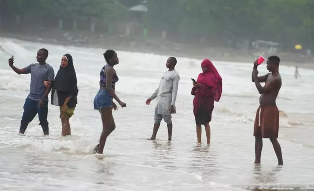 Beachgoers play at Takwa Bay beach in Lagos, Nigeria, Sunday, June 28, 2026. (AP Photo/Sunday Alamba)