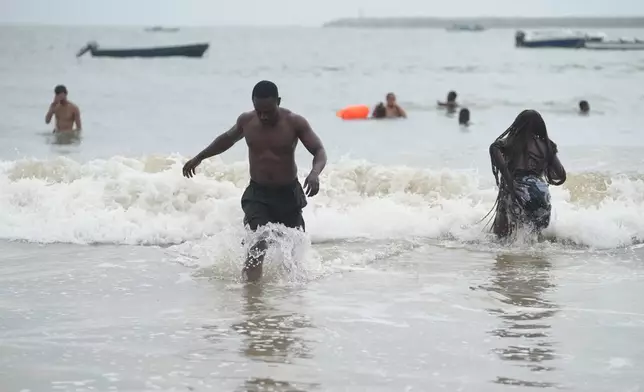 Mukthar Oladunmade, a 27-year-old writer, plays in the water at Takwa Bay beach in Lagos, Nigeria, Sunday, June 28, 2026. (AP Photo/Sunday Alamba)