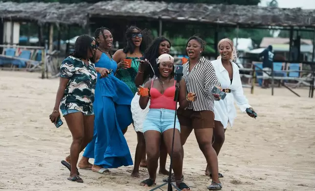 Beachgoers dance at Takwa Bay beach in Lagos, Nigeria, Sunday, June 28, 2026. (AP Photo/Sunday Alamba)