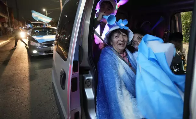 A family celebrates Argentina's victory over England in a World Cup semifinal soccer match while driving through Buenos Aires, Argentina, Wednesday, July 15, 2026. (AP Photo/Gustavo Garello)