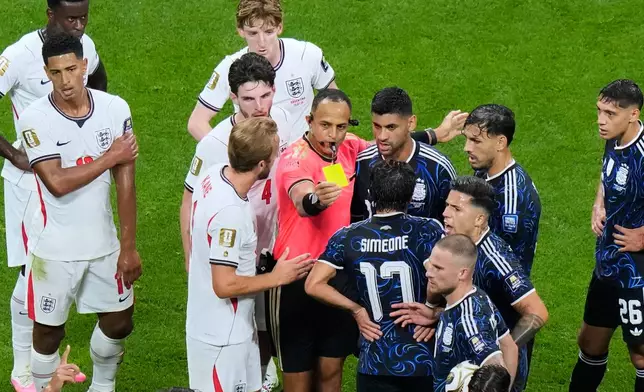 Referee Ismail Elfath, of the United States, separates players as he issues a yellow card to England's Elliot Anderson during the World Cup semifinal soccer match against Argentina in Atlanta, Wednesday, July 15, 2026. (AP Photo/Lynne Sladky)