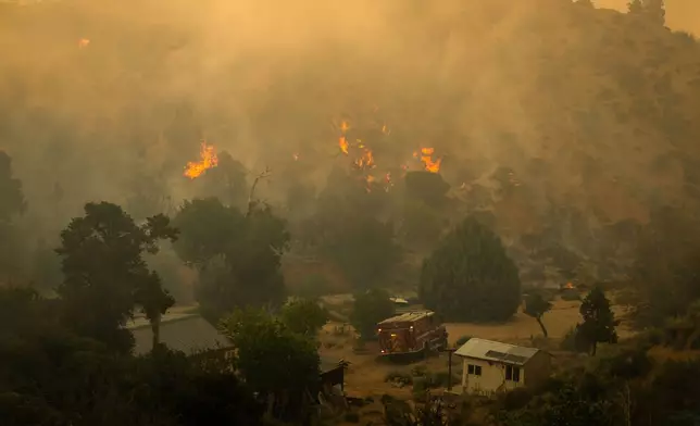 Flames rise on the Summit Fire in Llano, CA. Friday, July 10, 2026. (AP Photo/Ethan Swope)