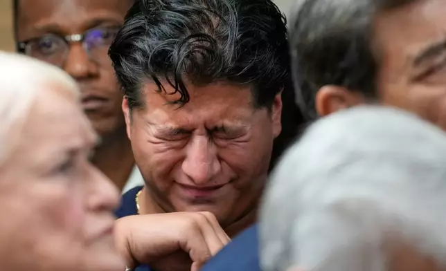 Ronaldo Salgado, son of Lorenzo Salgado Araujo, wipes away tears during a news conference Wednesday, July 8, 2026, in Houston. (AP Photo/David J. Phillip)