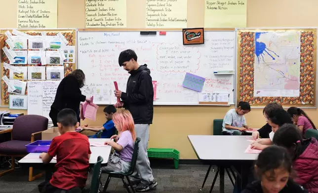 Chief Leschi Schools senior Gerald Dillon, 18, helps during a weaving exercise in a culture class for second graders as he serves as a teaching assistant through the school's career and technical education program, Wednesday, March 18, 2026, at Chief Leschi Schools in Puyallup, Wash. (AP Photo/Lindsey Wasson)