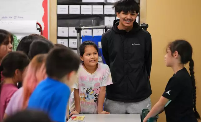 Chief Leschi Schools senior Gerald Dillon, 18, who serves as a teaching assistant through the school's career and technical education program, listens to a second grade student describe the parts of their Play-Doh insect in class Wednesday, March 18, 2026, at Chief Leschi Schools in Puyallup, Wash. (AP Photo/Lindsey Wasson)