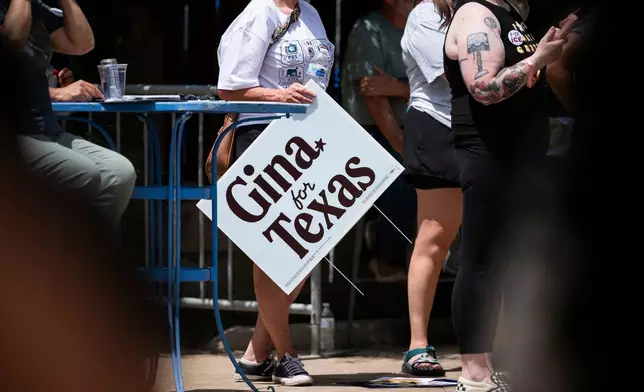 A supporter holds a sign for Democratic candidate for Texas governor Gina Hinojosa while she speaks during a rally, Saturday, July 18, 2026, in Lubbock, Texas. (AP Photo/Justin Rex)