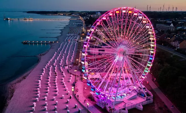 A Ferris wheel is illuminated at the beach on the Baltic Sea in Groemitz, Germany, Friday, July 10, 2026. (AP Photo/Michael Probst)